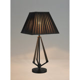 The Hilton 1 Light Large Wood Table Lamp features a black and grey base with a black shade, casting a warm glow on a light surface and standing out elegantly against a plain background.