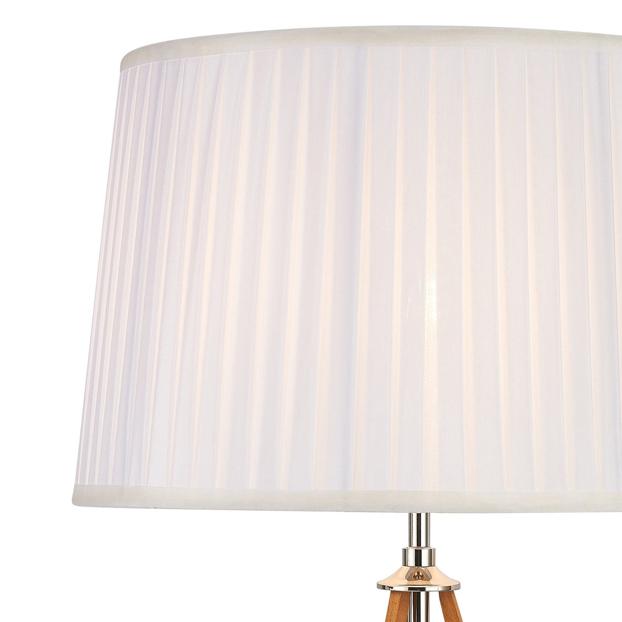 A close-up of the Hilton 1 Light Wood Table Lamp in nickel and taupe, featuring a pleated white cylindrical shade and a partially visible metal base, emitting soft, diffused light.