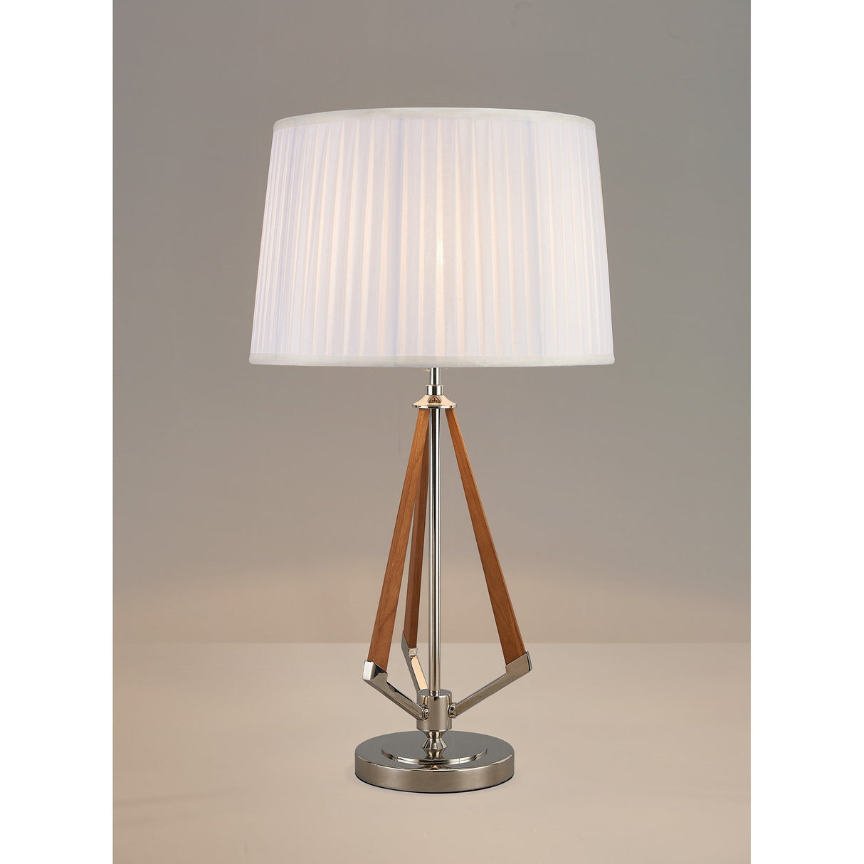The Hilton 1 Light Wood Table Lamp features a nickel and taupe base with angled wooden accents and a modern white pleated shade, displayed on a neutral surface against a plain background.