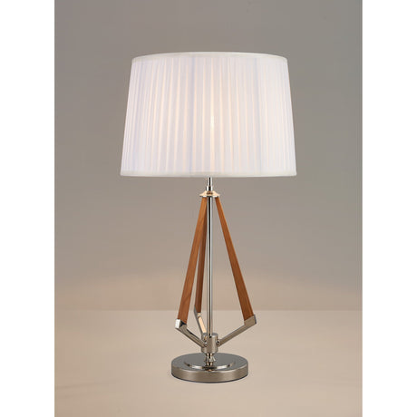 The Hilton 1 Light Wood Table Lamp features a nickel and taupe base with angled wooden accents and a modern white pleated shade, displayed on a neutral surface against a plain background.