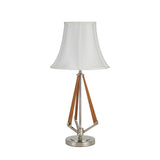 The Hilton 1 Light Wood Table Lamp features a nickel and taupe finish, cream shade, metallic round base, and three angled wooden supports connecting the base to the stem.