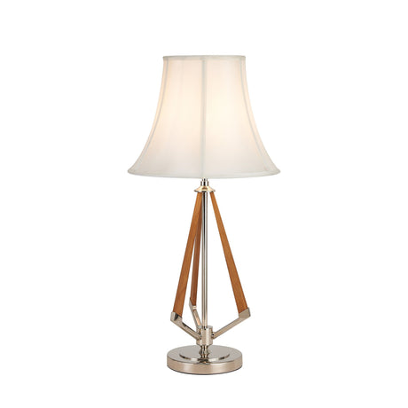 The Hilton 1 Light Wood Table Lamp features a nickel and taupe finish, cream shade, wooden angled supports, and a round chrome base, shown against a plain white background.