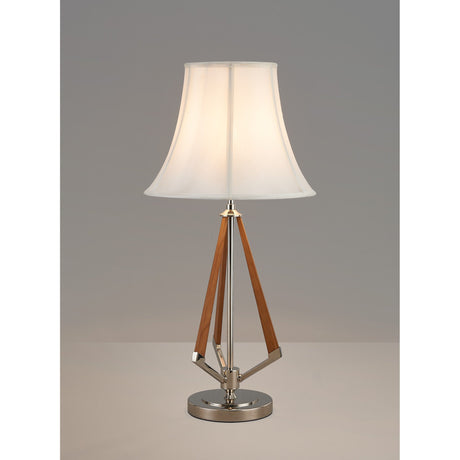 The Hilton 1 Light Wood Table Lamp features a nickel and taupe base with three geometric wooden legs and a cream shade, displayed against a plain gray background.
