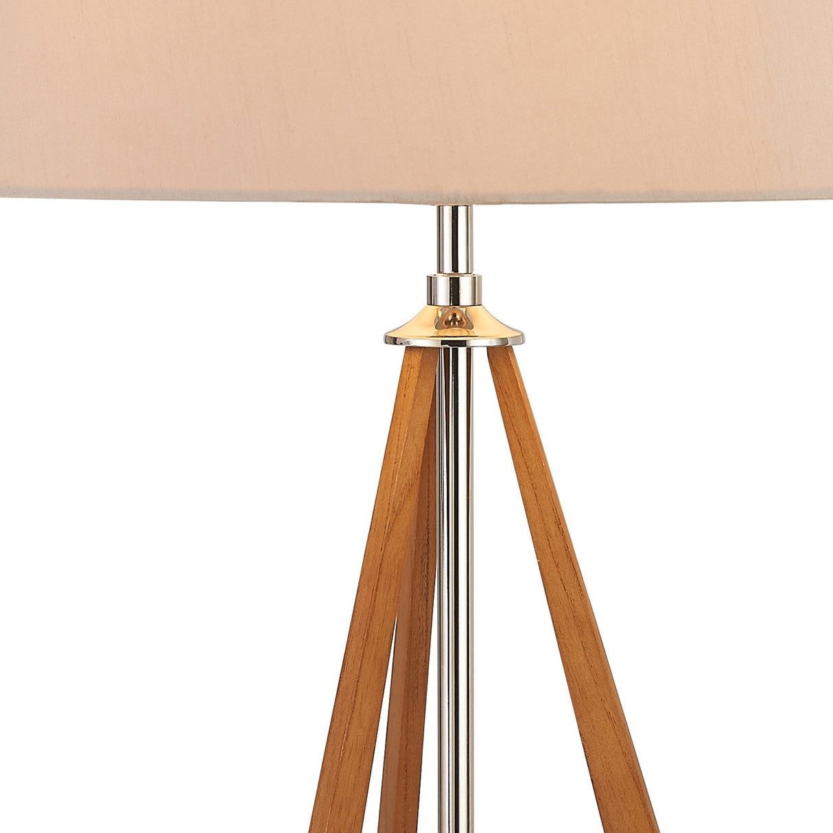 Close-up of the Hilton 1 Light Wood Table Lamp in nickel and taupe, featuring a central metal rod and three wooden legs forming a tripod base with a nude beige shade. Its modern design adds elegance to any space.