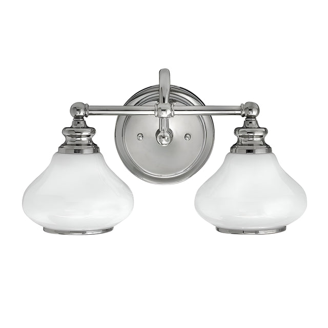 The Ainsley 2 Light Wall Light - Polished Chrome is a sleek and modern fixture featuring two frosted glass shades and a polished chrome metal base. Its classic yet contemporary design, equipped with LED lamps, makes it an ideal choice for a variety of room decors.