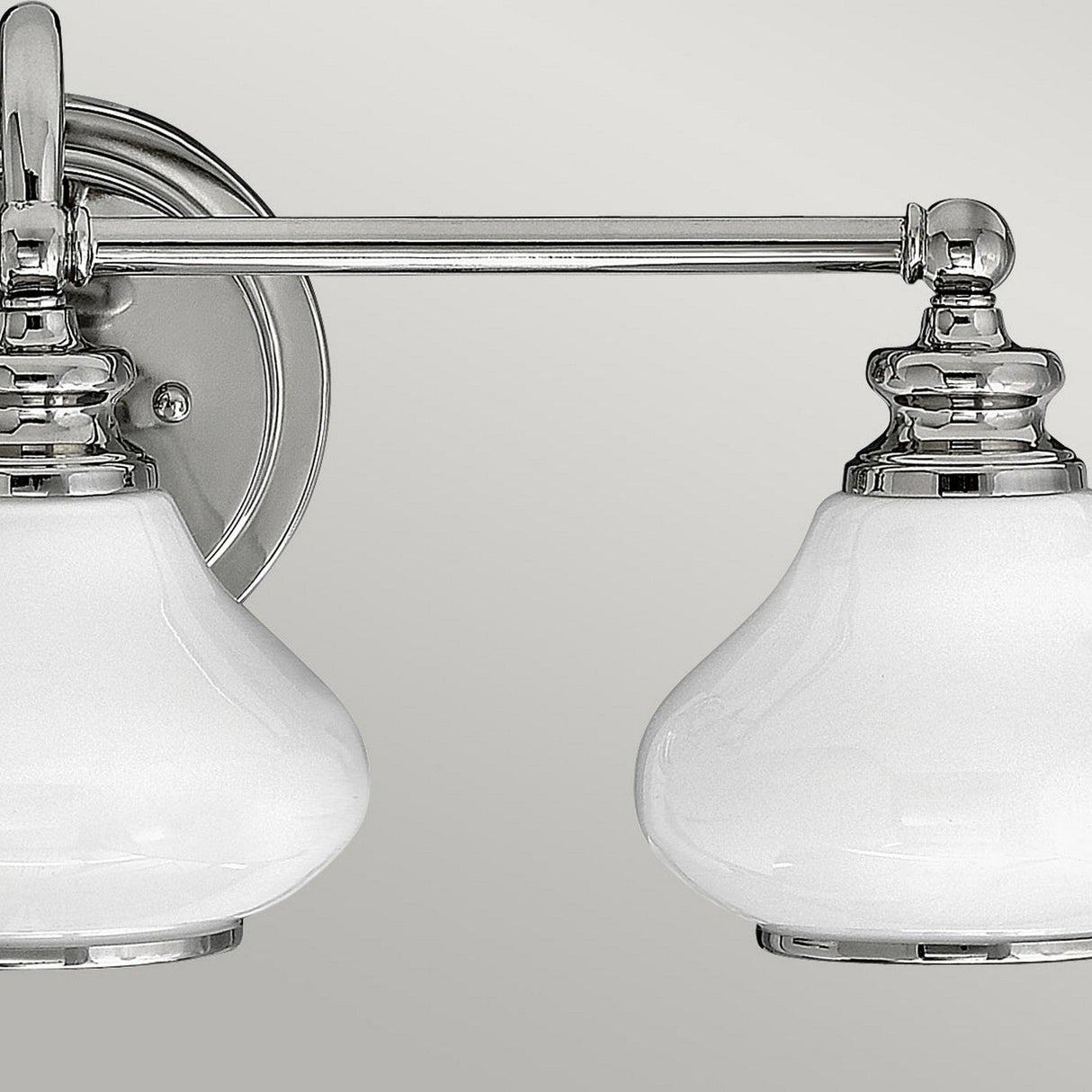 Introducing the Ainsley 3 Light Wall Light in polished chrome, this classic wall-mounted fixture showcases energy-efficient LED lamps with opal glass shades. It's designed with a round wall plate and a horizontal metal bar that supports all three lights.