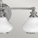 Introducing the Ainsley 3 Light Wall Light in polished chrome, this classic wall-mounted fixture showcases energy-efficient LED lamps with opal glass shades. It's designed with a round wall plate and a horizontal metal bar that supports all three lights.