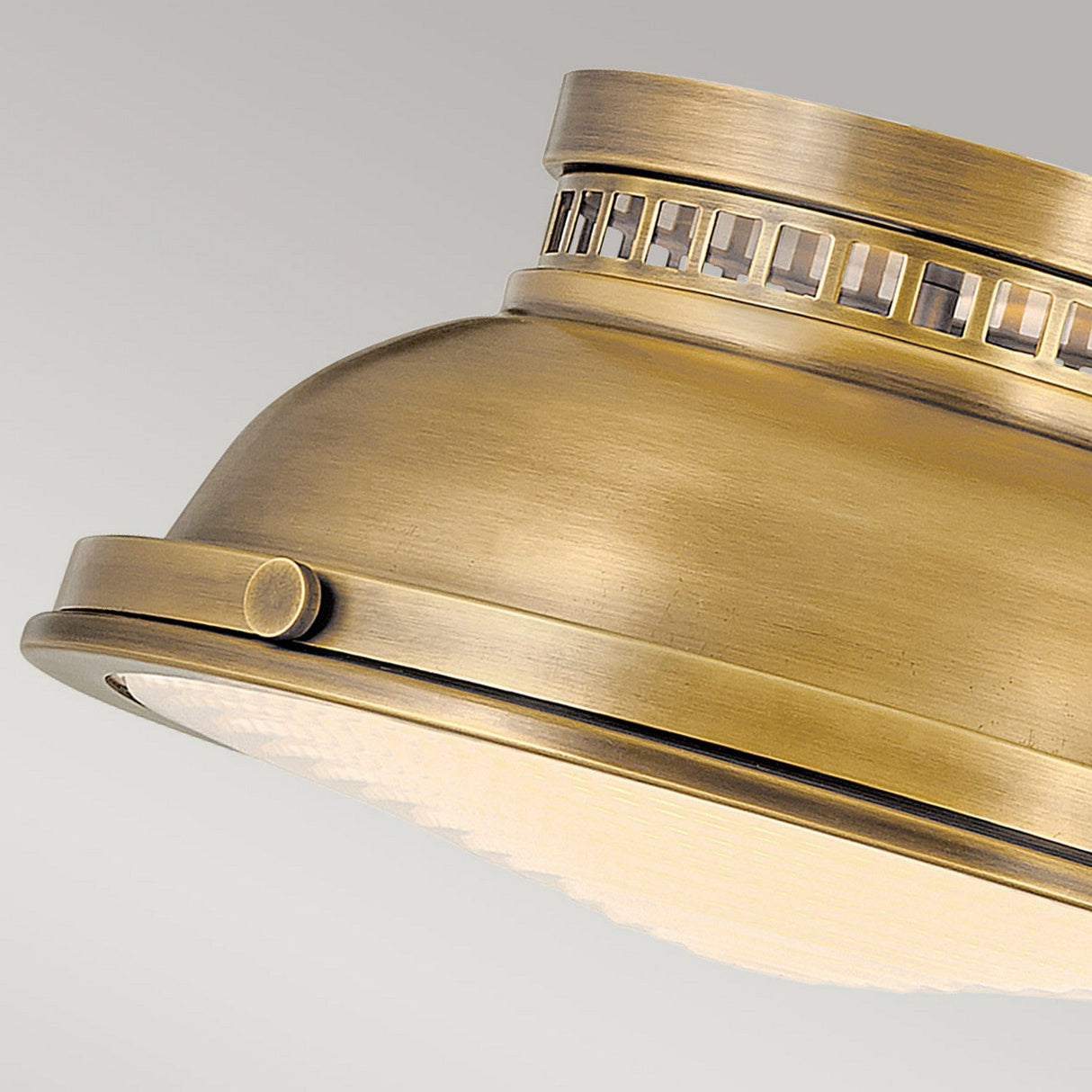 Featuring a close-up of the Amelia 2 Light Flush Light - Brass, this vintage-style ceiling fixture presents a dome-shaped design. Its intricate metalwork and frosted glass cover beautifully enhance its vintage charm, offering an elegant and classic aesthetic to any space.