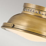 Featuring a close-up of the Amelia 2 Light Flush Light - Brass, this vintage-style ceiling fixture presents a dome-shaped design. Its intricate metalwork and frosted glass cover beautifully enhance its vintage charm, offering an elegant and classic aesthetic to any space.