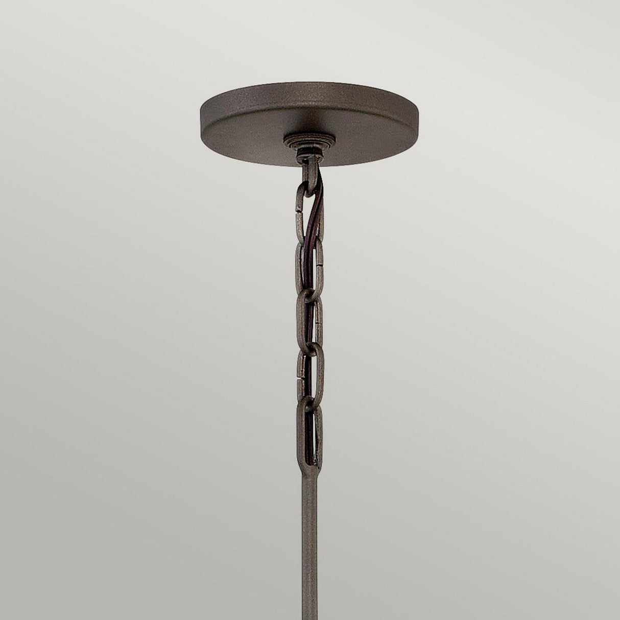 The Astrid 3 Light Chandelier, featuring a round, matte bronze and gold base with a short chain, is elegantly displayed against a plain light-gray background to enhance any space.