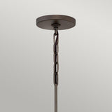The Astrid 3 Light Chandelier, featuring a round, matte bronze and gold base with a short chain, is elegantly displayed against a plain light-gray background to enhance any space.