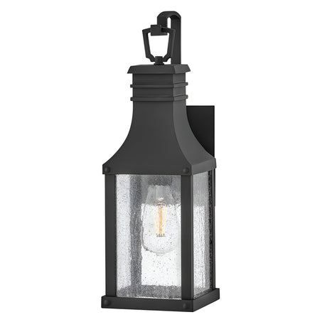 The Beacon Hill 1 Light Outdoor Small Wall Lantern in Black boasts a rectangular design with a clear seeded glass enclosure. Inside, it displays a single visible bulb and is elegantly topped with a decorative loop.