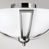 A close-up of the Bolla 2 Light Flush fixture, featuring a frosted glass shade and an angular brushed nickel frame, is set against a plain gray background, highlighting its sleek and sophisticated design.