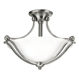 The Bolla 2 Light Semi Flush - Brushed Nickel fixture showcases an elegant design with a brushed nickel finish and frosted white glass shade, complemented by curved metal arms and a central stem connected to a round ceiling mount. This sophisticated piece enhances any home decor beautifully.