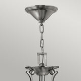A detailed view of the Bolla 3 Light Chandelier in brushed nickel, showcasing its chain link suspension and sleek, modern design with a conical ceiling mount.
