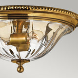 Introducing the Cambridge 2 Light Flush in Burnished Brass, this decorative ceiling light fixture showcases a transparent glass dome and an exposed bulb. Its design seamlessly blends New England decor with classic and modern elements, providing an elegant lighting solution.