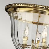 Close-up of the elegant Cambridge 3 Light Flush - Burnished Brass ceiling fixture, highlighting its classic New England style design. It includes three candle-shaped bulbs, a beaded edge, and clear glass panels, all set against a neutral background.