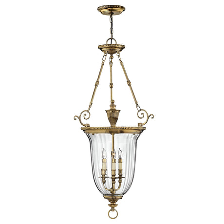 The Cambridge 3 Light Chandelier - Burnished Brass is a vintage-style fixture featuring a transparent glass dome with three candle-like lights. It is supported by ornate brass chains and decorative elements, all crafted in solid brass construction.