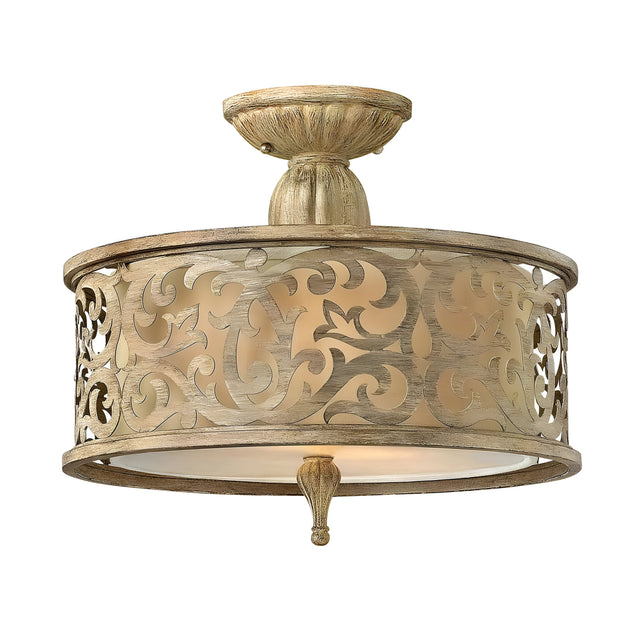 The Carabel 2 Light Small Semi Flush ceiling light, with its intricately scrolled beige metal frame, showcases a sophisticated brushed champagne finish. The design allows for a soft glow to shine through the translucent inner shade, bringing an elegant touch to any room.