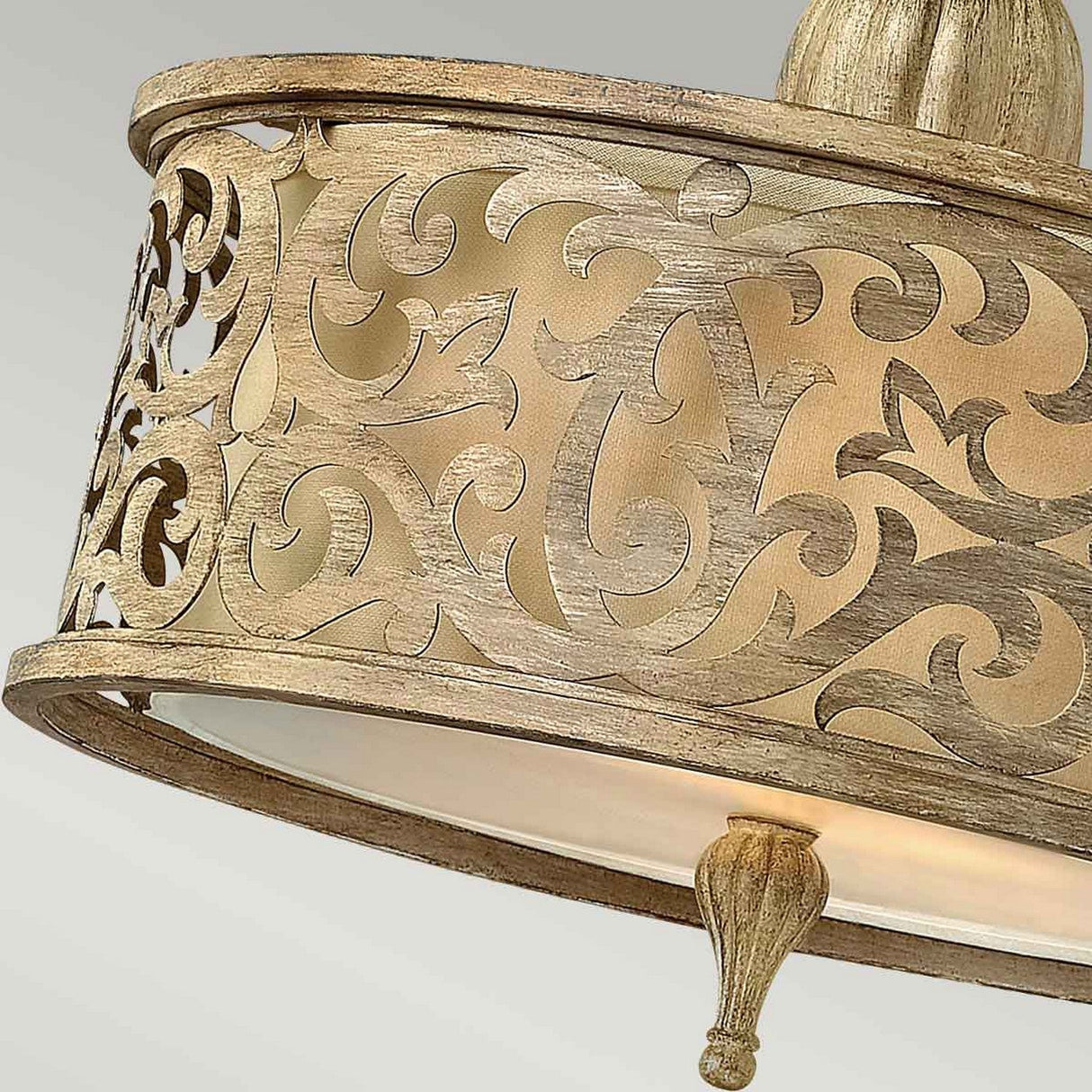 A close-up of the Carabel 2 Light Small Semi Flush fixture showcases its intricate scrollwork and elegant curved patterns in a brushed champagne finish, bringing a touch of vintage elegance to the design.
