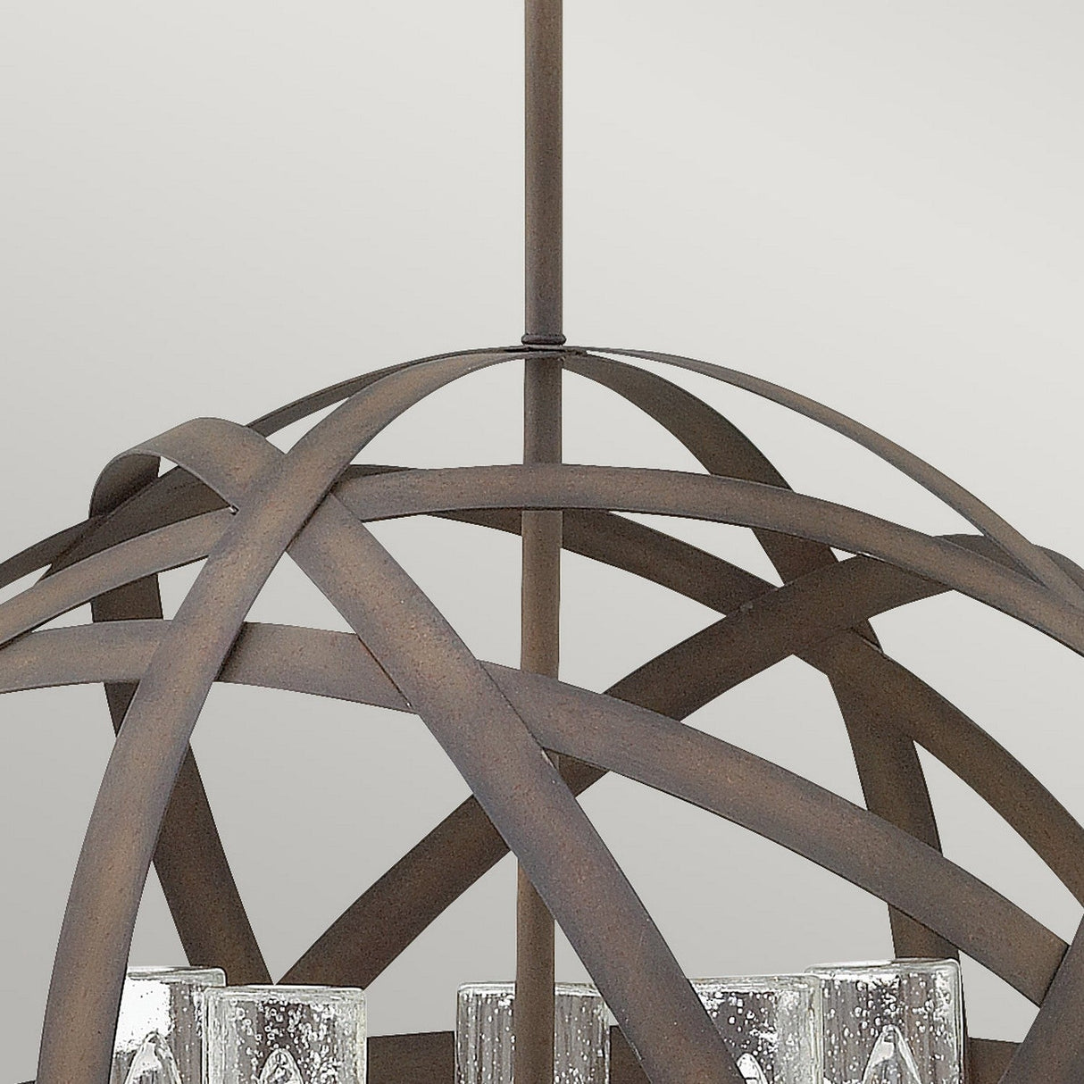 The Carson 5 Light Outdoor Chandelier in Vintage Iron features an orb-shaped metal frame with several candle-style light fixtures. The lights are turned off, highlighting the fixture's vintage iron elegance and showcasing its rustic charm.