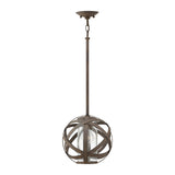 The Carson 1 Light Outdoor Pendant Light in Vintage Iron is a stunning piece, combining modern style with its spherical design of intersecting metal bands. It includes a central glass enclosure for the bulb, supported by a long rod and a ceiling fixture finished in bronze, making it perfect for outdoor use.