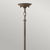 Presenting the Carson 1 Light Outdoor Pendant Light in Vintage Iron, this tall and modern floor lamp boasts a circular lampshade with a sleek design. Set against a plain background, it features a metal stem adorned with vintage iron chain-link detailing near the top, adding an industrial touch.
