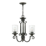 The Casa 3 Light Chandelier - Black exudes classic elegance with its black wrought iron frame and twisted metal arms. Its clear cylindrical glass shades, reminiscent of seedy glass, enhance its timeless appeal, while a sturdy chain ensures easy hanging.