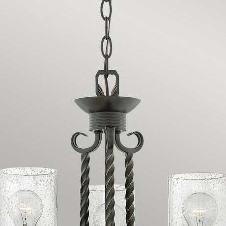 Close-up of the Casa 3 Light Chandelier - Black, showcasing a dark metal frame with twisted rods. It features two seedy glass shades, each housing a visible bulb. This elegant black chandelier is suspended from a chain against a neutral background.