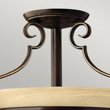 Close-up of the elegant Cello 2 Light Semi Flush chandelier in antique bronze, showcasing its dark metallic finish. It features gracefully curved metal arms and a wooden trim, effortlessly combining contemporary and traditional design elements against a neutral background.