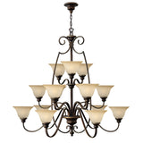 The Cello 15 Light Chandelier in Antique Bronze is a large and elegant fixture with two tiers of vintage faux alabaster glass lampshades. It features intricate scrollwork details and is suspended from a decorative chain.
