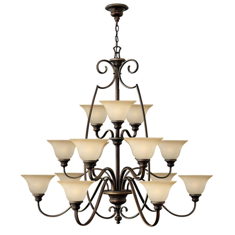 The Cello 15 Light Chandelier in Antique Bronze is a large and elegant fixture with two tiers of vintage faux alabaster glass lampshades. It features intricate scrollwork details and is suspended from a decorative chain.
