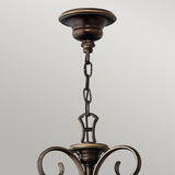 The Cello 15 Light Chandelier in Antique Bronze boasts an intricate, curved design complemented by vintage-style faux alabaster glass. It is suspended elegantly from a chain linked to a decorative ceiling mount. The image emphasizes the upper portion of the chandelier against a plain backdrop.