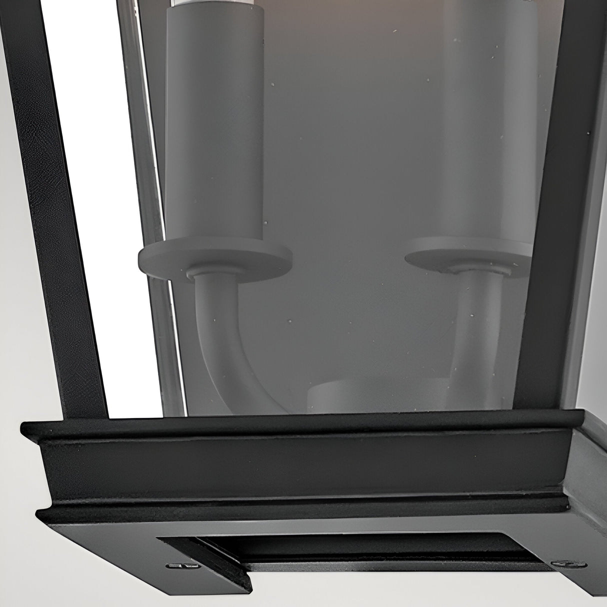 Close-up of the Chapel Hill 2 Light Outdoor Half Wall Lantern in black, featuring a modern metal frame, glass panel, mounting base, and two unlit candle-style bulb sockets for an elegant carriage house look.