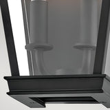 Close-up of the Chapel Hill 2 Light Outdoor Half Wall Lantern in black, featuring a modern metal frame, glass panel, mounting base, and two unlit candle-style bulb sockets for an elegant carriage house look.