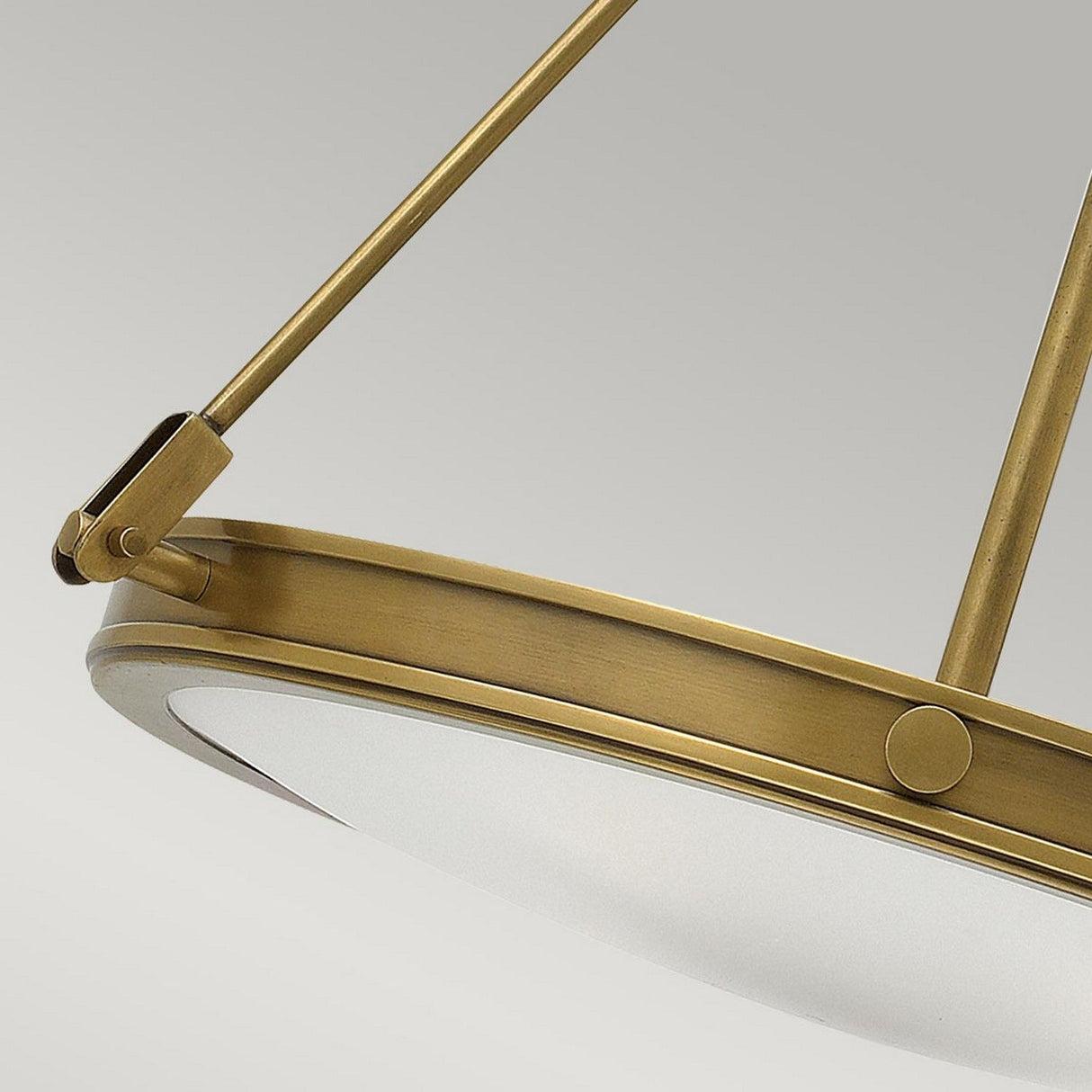 Close-up of the Collier 4 Light Chandelier - Heritage Brass, featuring a circular design and a frosted glass shade. Emphasizing its metal frame and robust support rods, it highlights an elegant, modern style reminiscent of Mid-Century Design against a neutral backdrop.
