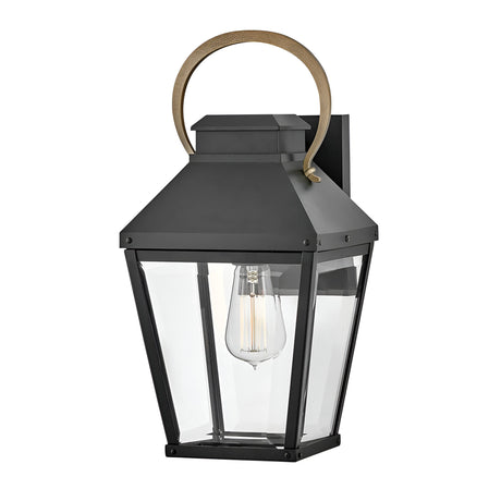 The Dawson 1 Light Outdoor Medium Wall Lantern in Black Oxide features clear glass panels, a visible bulb, and a gold handle detail—ideal for patio lighting.
