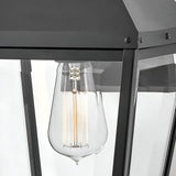 The Dawson 1 Light Outdoor Medium Wall Lantern in Black Oxide features a clear glass bulb with visible filaments, set in a sleek metal frame and glass panels—ideal for stylishly enhancing your patio lighting.