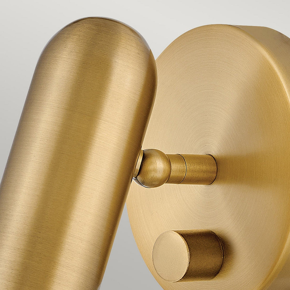 Close-up of the Dax LED Wall Light - Heritage Brass, featuring a cylindrical design and round base, showcasing modern elegance with its brushed metallic finish.