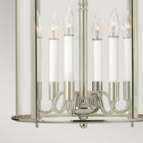 A close-up of the sophisticated Gentry 6 Light Large Pendant - Polished Nickel showcases its six candle-like bulbs and clear bent glass panels against a light gray background, enhancing its elegant charm.