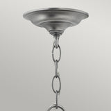 Close-up of the Gentry 4 Light Medium Pendant in brushed silver, featuring a chain extending downward. The chain elegantly passes through the loop, accentuating its sophisticated design with clear bent glass panels, creating an exquisite silhouette against a plain light gray background.