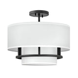 Introducing the Graham 3 Light Duo-Mount Pendant/Semi-Flush in Black, a contemporary ceiling light fixture with a sleek design. It features a black welded frame and two concentric cylindrical white fabric shades for a modern look.