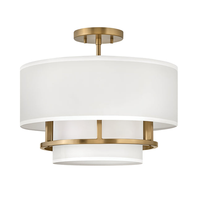 The Graham 3 Light Duo-Mount Pendant/Semi-Flush - Lacquered Brass is a modern ceiling fixture featuring a cylindrical white fabric shade complemented by lacquered brass accents and a brass ceiling mount. Its sophisticated design combines contemporary aesthetics with dual-mount capability, offering versatile installation options.
