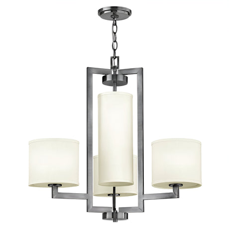 The Hampton 4 Light Chandelier - Antique Nickel with Ivory Shade showcases a contemporary, transitional design featuring three cylindrical ivory lampshades. These shades are arranged in a triangular formation and suspended by a chain from a rectangular frame. The central shade is larger, contributing an elegant touch to the fixture's overall appearance.