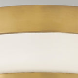 A close-up of the Harper 3 Light Flush in heritage brass and opal etched glass, showcasing its elegant curved design against a gray background, which suggests it is part of a decorative item or furniture piece.