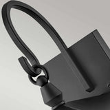 Close-up of the Huntersfield Outdoor 2 Light Medium Wall Lantern in black, featuring a modern curved design with interconnected loops, crafted from durable aluminum, set against a light gray background.
