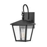 The Huntersfield Outdoor 1 Light Small Wall Lantern - Black features a black finish and clear glass shade, highlighting a visible Edison-style bulb. Its square backplate and decorative hook contribute to its classic, vintage-inspired design, perfect for enhancing any outdoor lighting scheme.