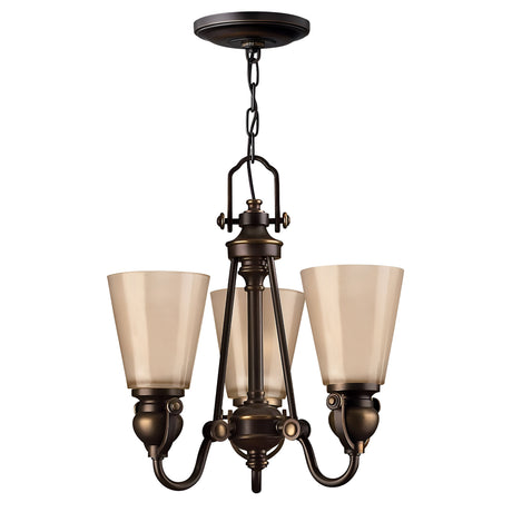 The Mayflower 3 Light Chandelier in a bronze finish, featuring frosted glass shades, exudes traditional elegance with its central fixture suspended from a chain and showcasing intricate metalwork alongside modern design elements.