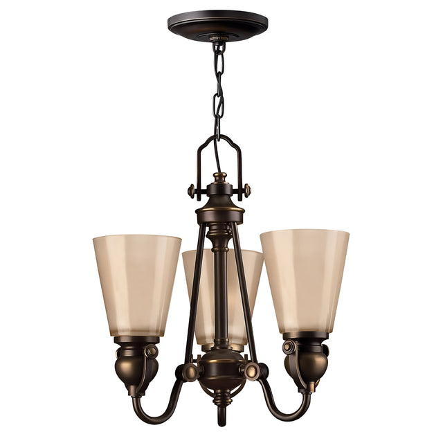 The Mayflower 3 Light Chandelier in a bronze finish, featuring frosted glass shades, exudes traditional elegance with its central fixture suspended from a chain and showcasing intricate metalwork alongside modern design elements.