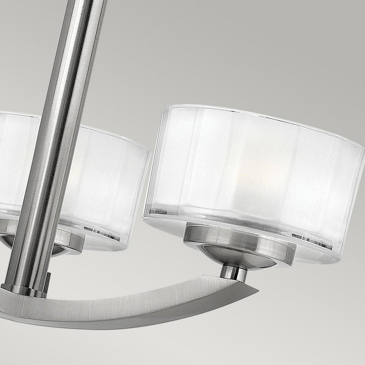 Close-up of the Meridian 3 Light Semi Flush in a brushed nickel finish, featuring frosted cylindrical glass shades, set against a neutral background. This energy-efficient design is minimalist and ideal for modern interiors.